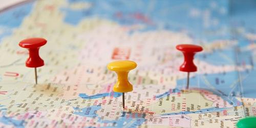 paper map with several different coloured pins in it